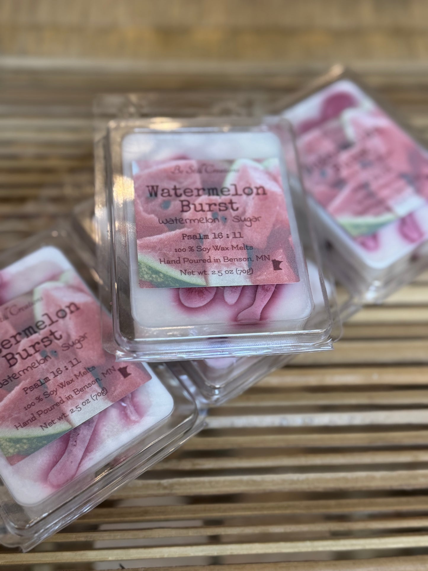 Watermelon Burst wax melts in clear packaging on a wooden surface