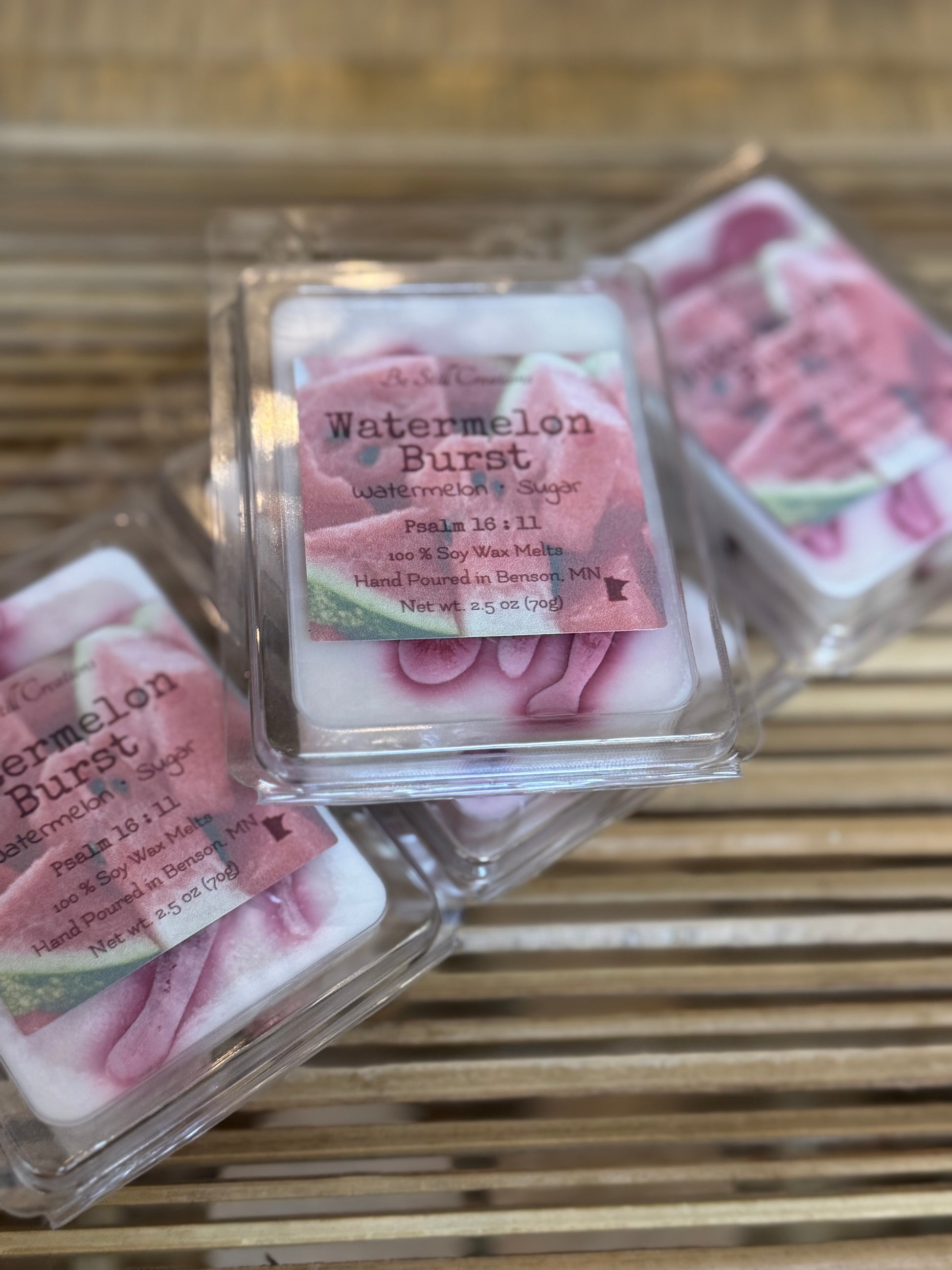 Watermelon Burst wax melts in clear packaging on a wooden surface