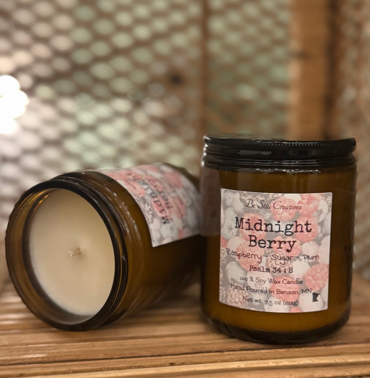 Midnight Berry soy candle in clear glass jar with pink wax and black lid, raspberry plum scent