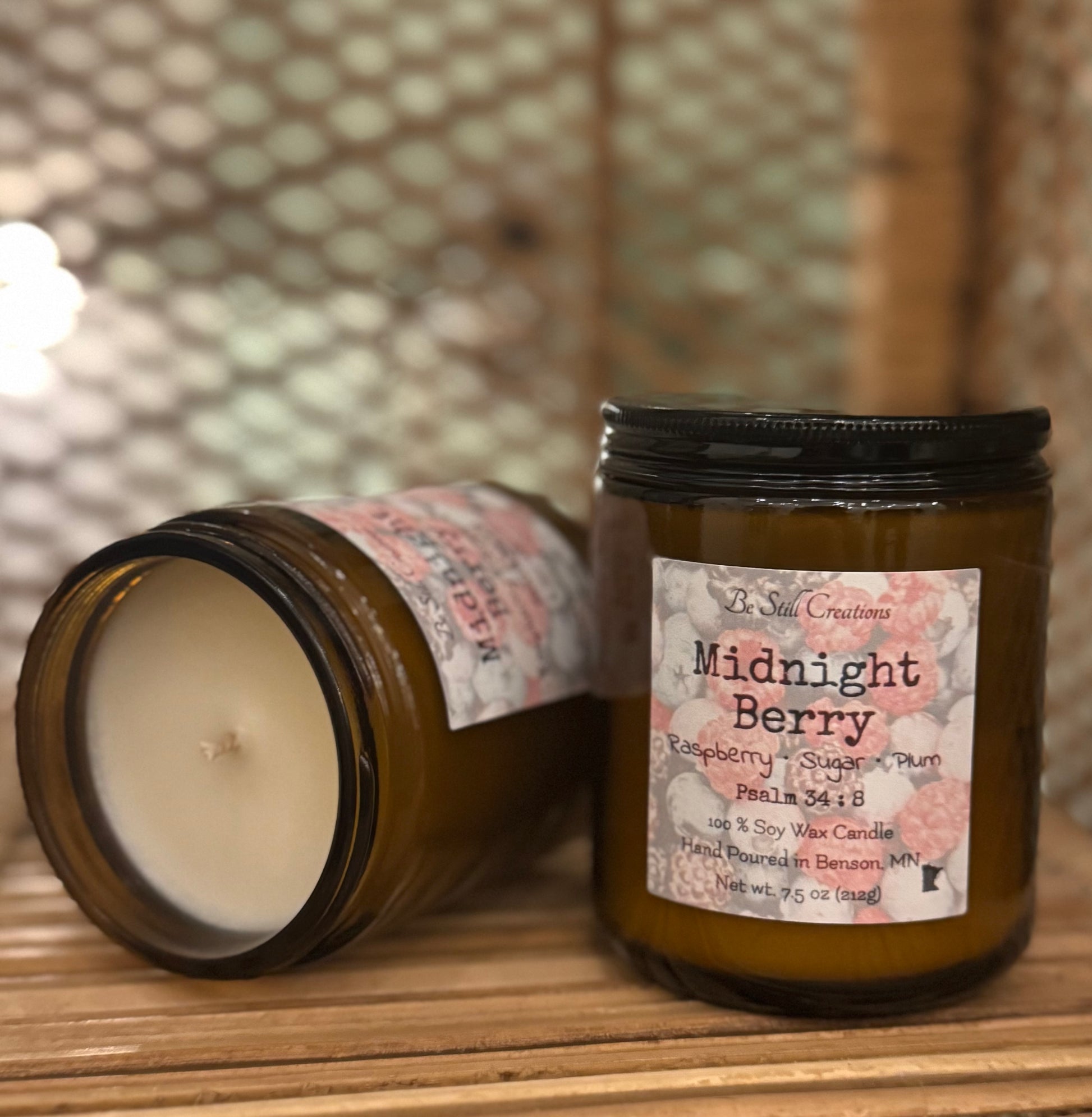 Midnight Berry soy candle in clear glass jar with pink wax and black lid, raspberry plum scent