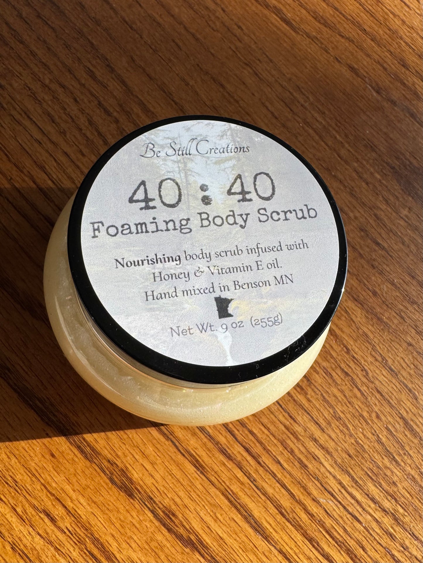 40:40 Foaming Body Scrub container on a wooden surface