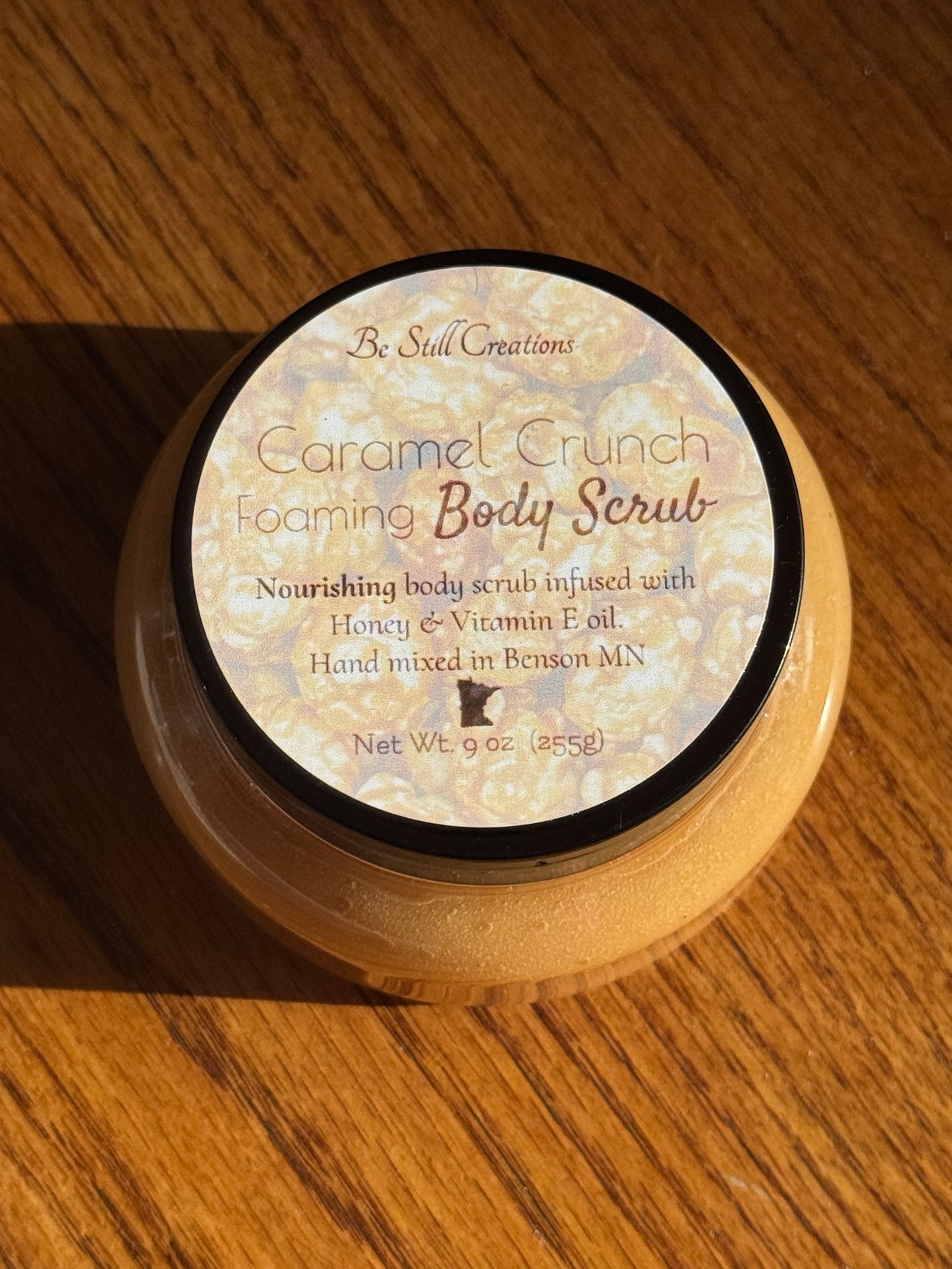 Jar of Carmel Crunch Foaming Body Scrub on a wooden surface